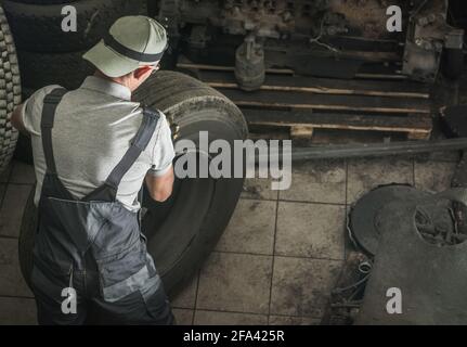 Caucasian Automotive Worker in His 40s Replacing Heavy Duty Truck Wheel For the New One. Semi Truck Service. Stock Photo