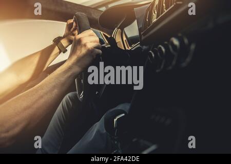 Modern Performance Car Driver. Caucasian Men Behind Sporty Exotic Vehicle Steering Wheel. Super Car Theme. Stock Photo