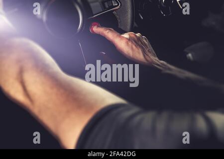 Modern Sporty Car Ignition Start Button. Pressing by Caucasian Driver. Automotive Technology Theme. Stock Photo