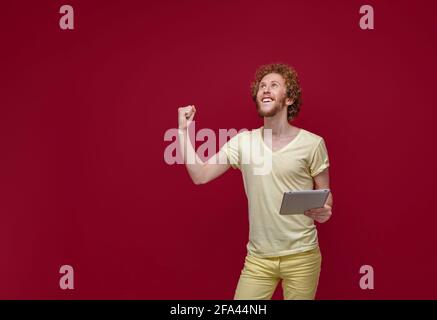 Young curly-haired man with tablet Stock Photo