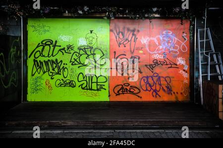 Osaka, Japan - November 5 2020: Graffiti covers the green and orange neon-colored doors of a garage in central Osaka Stock Photo
