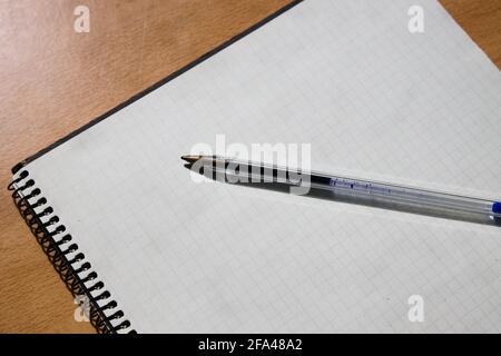 Image of a table in which there is a pen on a worm notebook with blank pages. Concept, copy space Stock Photo