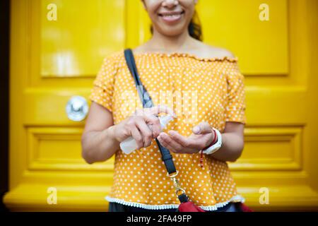 unrecognizable woman on the street applying hand sanitizer Stock Photo