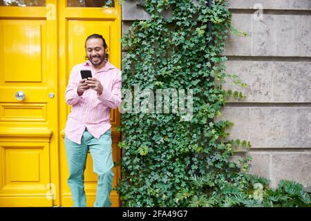 happy young man listening music using his smarthphone on the street Stock Photo