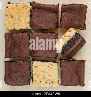 Nine square shaped cuted brownies white and black flat lay Stock Photo