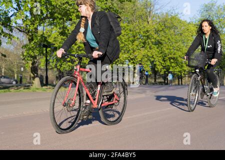 Two women cyclists commute to work in sunny spring afternoon, London Stock Photo