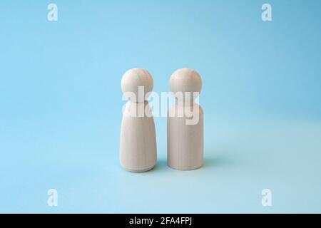 Wooden people figures of man and woman on blue backdrop, relationship, communication problems between wife and husband. Stock Photo