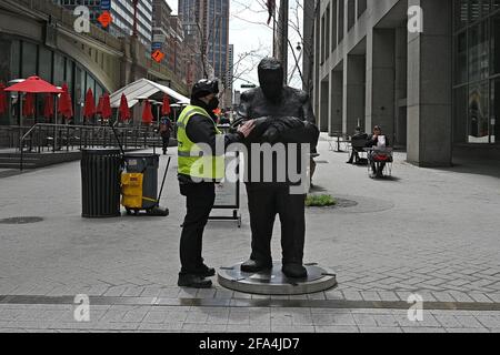 New York, USA. 22nd Apr, 2021. A security guard touches the arm of “Timing”, one of three new sculptures by New York artist Jim Rennert, on display in Pershing Square Plaza, across from Grand Central Terminal, in New York, NY, April 22, 2021. Three sculptures, titled “Timing”, Inner Dialogue” and “Listen” are part of the Department of Transportations Temporary Art Program. (Photo by Anthony Behar/Sipa USA) Credit: Sipa USA/Alamy Live News Stock Photo