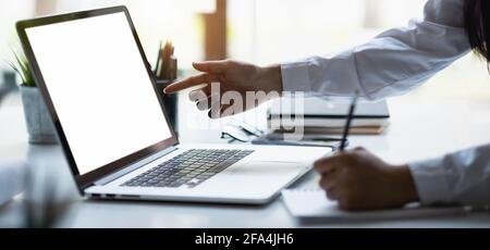 Business woman work process concept. female graphic designer pointing with finger on laptop computer during collaboration draft on paper. Stock Photo