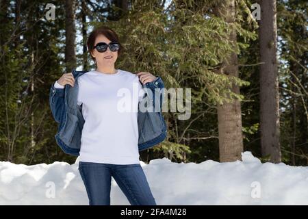 White fleece crewneck sweatshirt mockup featuring a woman wearing denim jacket. Heavyweight sweatshirt template, model mockup Stock Photo