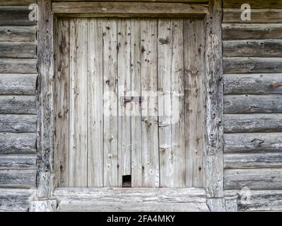 closed barn door with padlock on weathered wooden wall Stock Photo