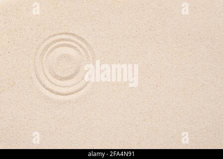 Smooth texture of white sand, top view, layout. Round pattern on sandy background. Concept picture about zen, relaxation, Japanese meditation. Stock Photo