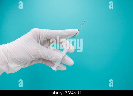 Doctors hand with syringe and vaccine for immunization against COVID-19. Stock Photo