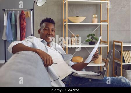 Successful young African businessman working on laptop in comfortable home office Stock Photo