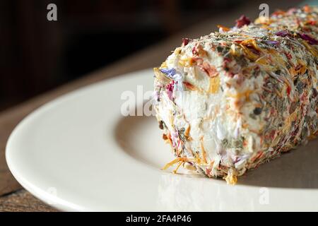 Fresh french goat cheese with honey and flowers on the light plate close-up Stock Photo