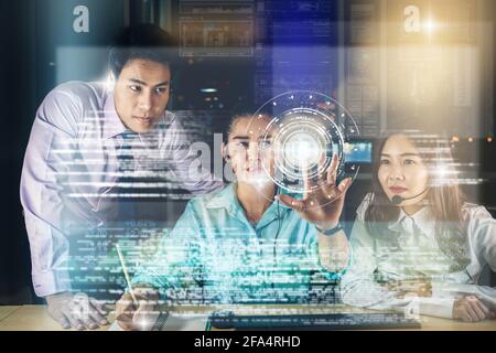 Group of business People working hard late with her technology computer  over visual screen in office at night, Customer service and Working hard for Stock Photo