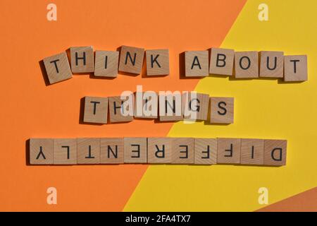 Think About Things Differently, words in wooden alphabet letters    isolated on colourful background Stock Photo