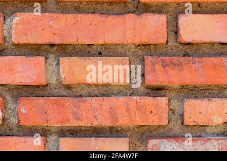 Damaged brick wall with weathered cracks and damage close-up Stock Photo