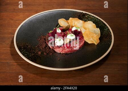 Tasty sweet tartar dish on black plate perspective view Stock Photo