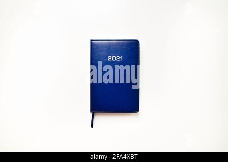Top view blue notes book calendar with 2021 year title. Resolutions and journalism new year concept. Stock Photo