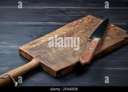 empty wooden cutting board and knife on rustic kitchen table Stock Photo