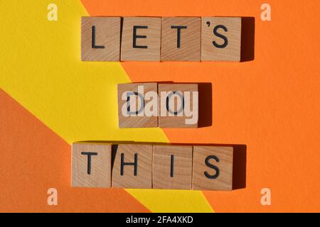 Let's Do This, motivational words in wooden alphabet letters isolated on yellow and orange background Stock Photo