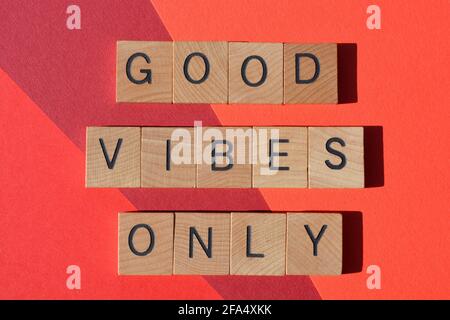 Good Vibes Only, positive phrase in wooden alphabet letters isolated on red background Stock Photo