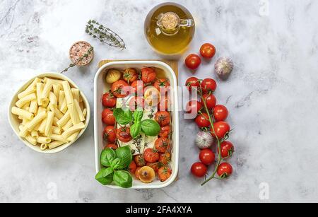 Trending viral Feta baked pasta recipe made of cherry tomatoes, feta cheese, garlic, and herbs in a casserole dish. Great sauce for rigatoni or penne. Stock Photo