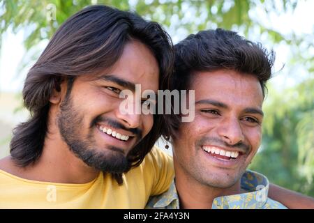 Happy young Indian gay couple looking at their photos on the phone