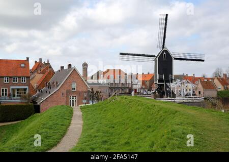 The old Harbor of Heusden, North Brabant, Netherlands, a fortified city located 19km far from Hertogenbosch, with a windmill in the foreground Stock Photo