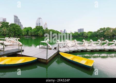 White duck boat pedal or Paddle goose boat in the lake, Anonymous people spend some time relaxing with family, couples in the park,Lumphini public par Stock Photo