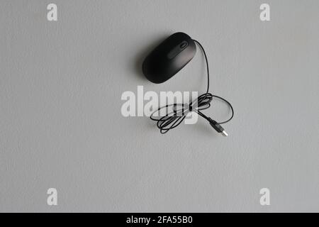 Closeup black minimalist mouse attached to white cement wall Stock Photo