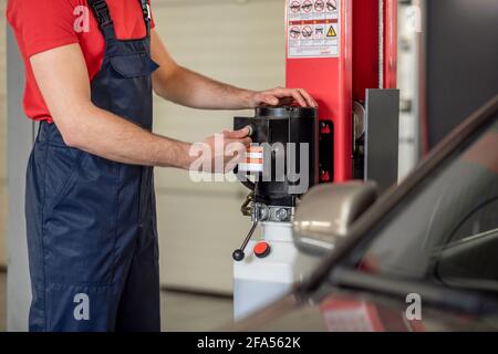 Male hands pressing button of device in garage Stock Photo