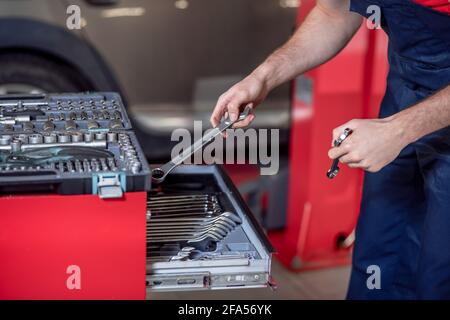 Male hands with wrenches near open toolbox Stock Photo