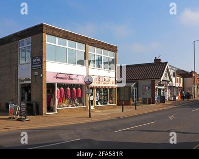 A view of shop fronts by the A1151 road north of Wroxham Bridge on the Norfolk Broads at Hoveton, Norfolk, England, United Kingdom. Stock Photo
