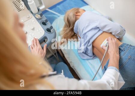 Process of conducting ultrasound session by doctor on patient Stock Photo