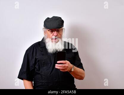 Senior man reading a shocking text message on his cellphone Stock Photo