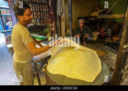 Ujjain, India - March 2021: A man making chapatis on a street in Ujjain on March 24, 2021 in Madhya Pradesh, India. Stock Photo