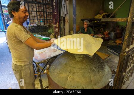 Ujjain, India - March 2021: A man making chapatis on a street in Ujjain on March 24, 2021 in Madhya Pradesh, India. Stock Photo