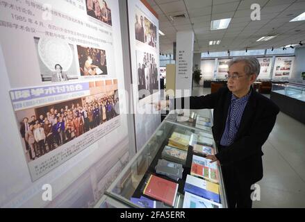 (210423) -- CHENGDU, April 23, 2021 (Xinhua) -- Yang Wuneng offers visitors a guide at an exhibition area dedicated to his translation achievements at Chongqing Library in southwest China's Chongqing Municipality, April 18, 2021.  In a career that spans over 60 years, Yang Wuneng has translated 31 German classics into the Chinese language, including 'Faust', 'Selected Poems of Heinrich Heine' and 'Immensee.' Many of his translations are still bestselling books in some bookstores. His translation of 'Grimms' Fairy Tales,' for instance, has been popular among Chinese readers for many generations Stock Photo