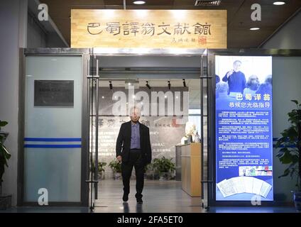 (210423) -- CHENGDU, April 23, 2021 (Xinhua) -- Yang Wuneng poses for a photo at an exhibition area dedicated to his translation achievements at Chongqing Library in southwest China's Chongqing Municipality, April 18, 2021. In a career that spans over 60 years, Yang Wuneng has translated 31 German classics into the Chinese language, including 'Faust', 'Selected Poems of Heinrich Heine' and 'Immensee.' Many of his translations are still bestselling books in some bookstores. His translation of 'Grimms' Fairy Tales,' for instance, has been popular among Chinese readers for many generations. Today Stock Photo