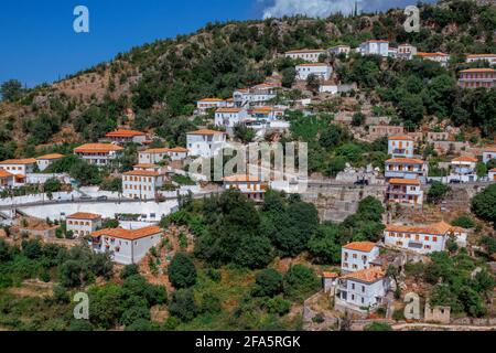 Vuno/ Albania - August 7, 2020: view of the village - traditional white houses with orange roofs and wooden shutters on windows - on the mountain hill Stock Photo