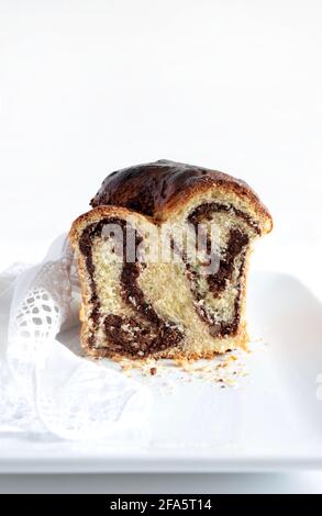 Homemade traditional Romanian sweet bread named "cozonac", with cacao, raisins, and nuts on white background. Stock Photo