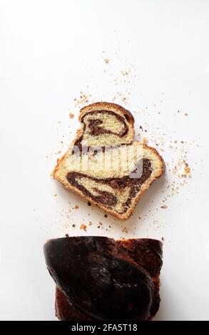 Homemade traditional Romanian sweet bread named "cozonac", with cacao, raisins, and nuts on white background. Stock Photo