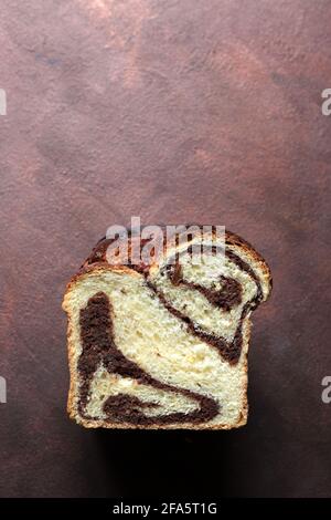 Homemade traditional Romanian sweet bread named "cozonac", with cacao, raisins, and nuts. Eastern European baked dessert. Babka. Stock Photo