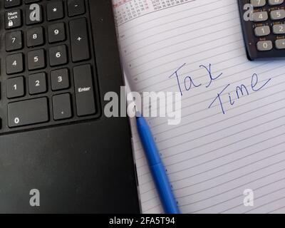 A diary with text TAX TIME and calculator,pen,laptop. Stock Photo