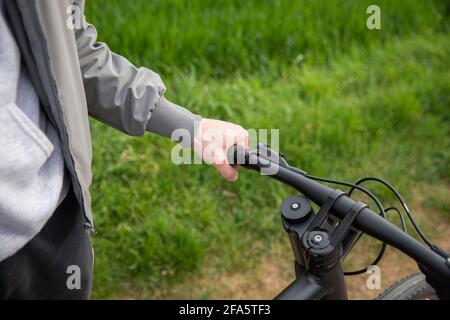 Close-up of a boy's hand grabbing the handlebars of his bicycle. Stock Photo