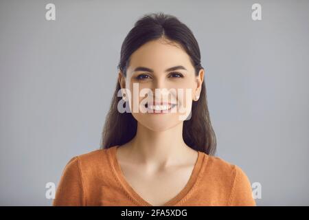Happy young caucasian woman smiling to camera headshot studio portrait Stock Photo