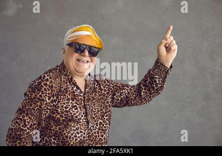 Headshot portrait of funny stylish handsome old man pointing up with finger Stock Photo