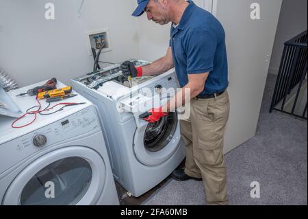 Appliance technician working on a front load high efficiency washing machine Stock Photo